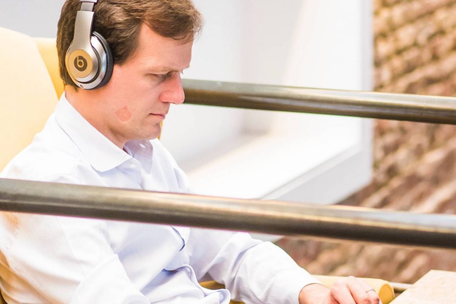 Man wearing headphones typing on the laptop