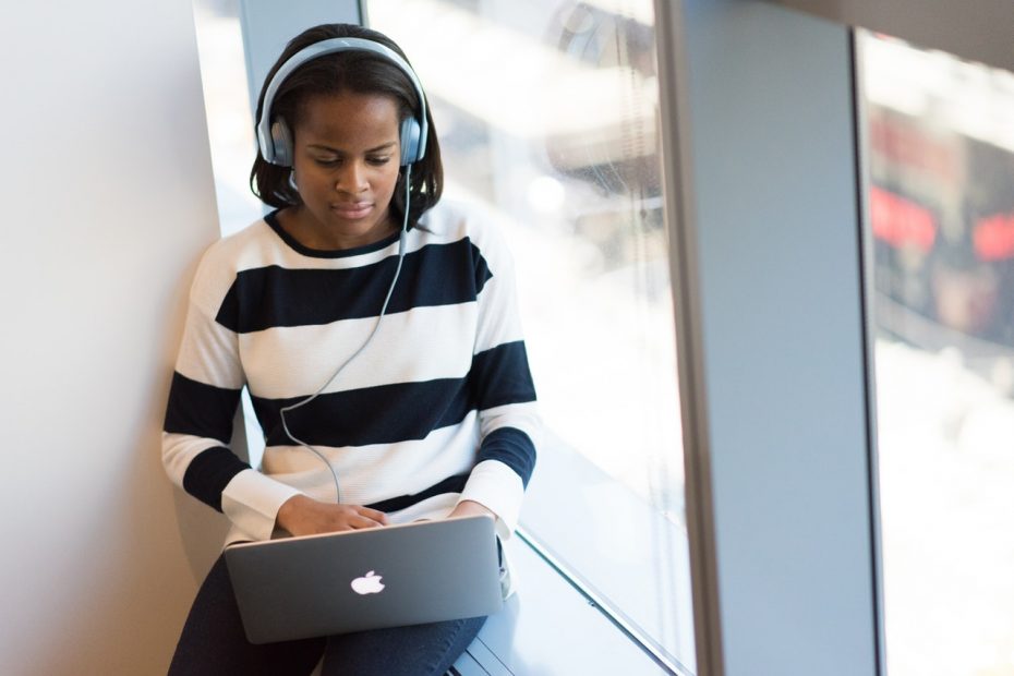 woman transcribing with headphones