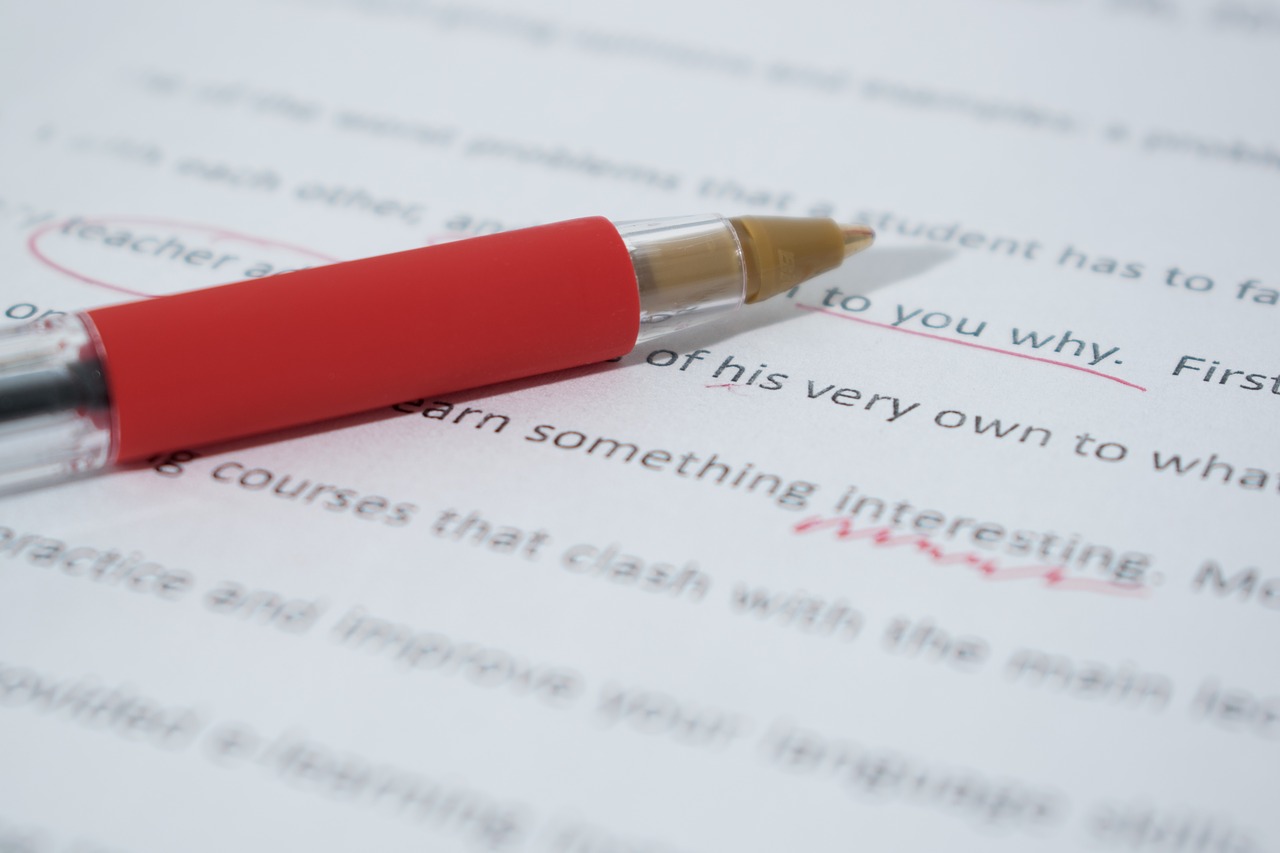 a close up image of a paper being proofread using a red pen